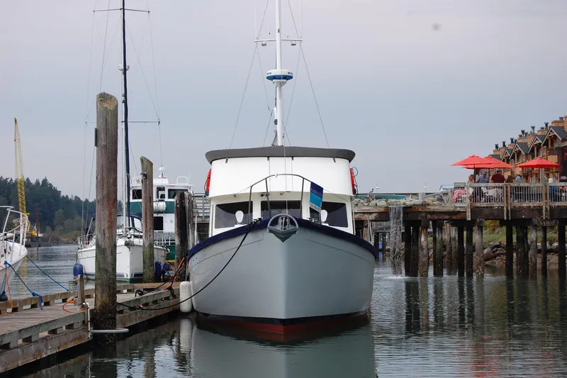 Slide: The Image of 1981 Willard Marine Pilot House Trawler docked at a marina with waterfront buildings. - 2