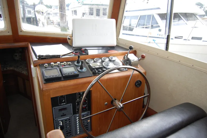 Slide: The Image of 1981 Willard Marine Pilot House Trawler helm with steering wheel and navigation controls. - 21