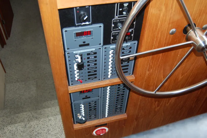 Slide: The Image of 1981 Willard Marine Pilot House Trawler control panel with steering wheel and electrical switches. - 23