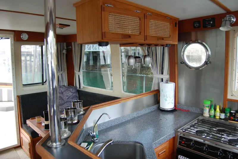 Slide: The Image of Interior of 1981 Willard Marine Pilot House Trawler with kitchen and dining area. - 26