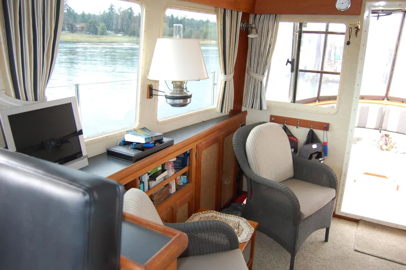 Slide: The Image of 1981 Willard Marine Pilot House Trawler interior with seating, books, and scenic window view. - 27