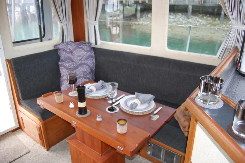 Slide: The Image of Cozy dining area in 1981 Willard Marine Pilot House Trawler with elegant table setting. - 28