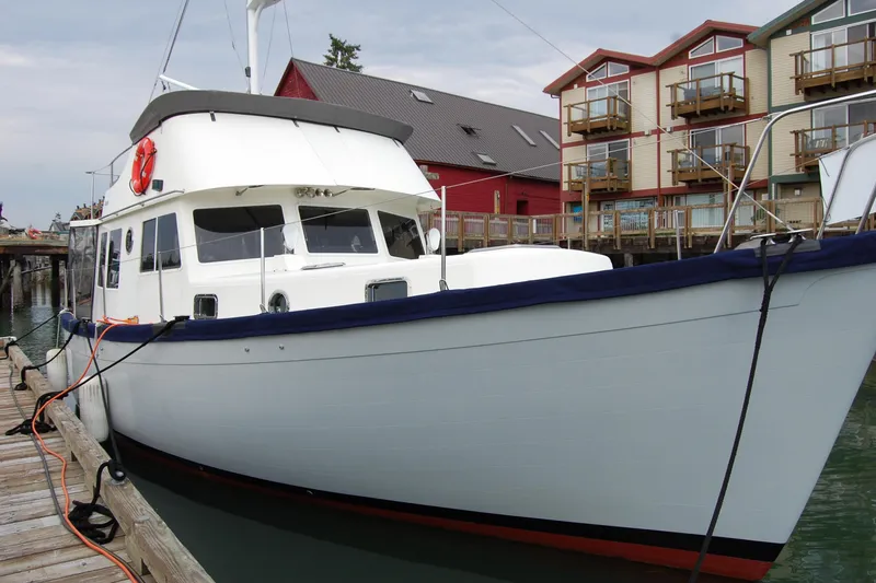 Slide: The Image of 1981 Willard Marine Pilot House Trawler docked near colorful waterfront buildings. - 3