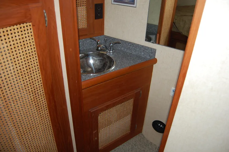 Slide: The Image of 1981 Willard Marine Pilot House Trawler bathroom with wooden cabinetry and stainless steel sink. - 34