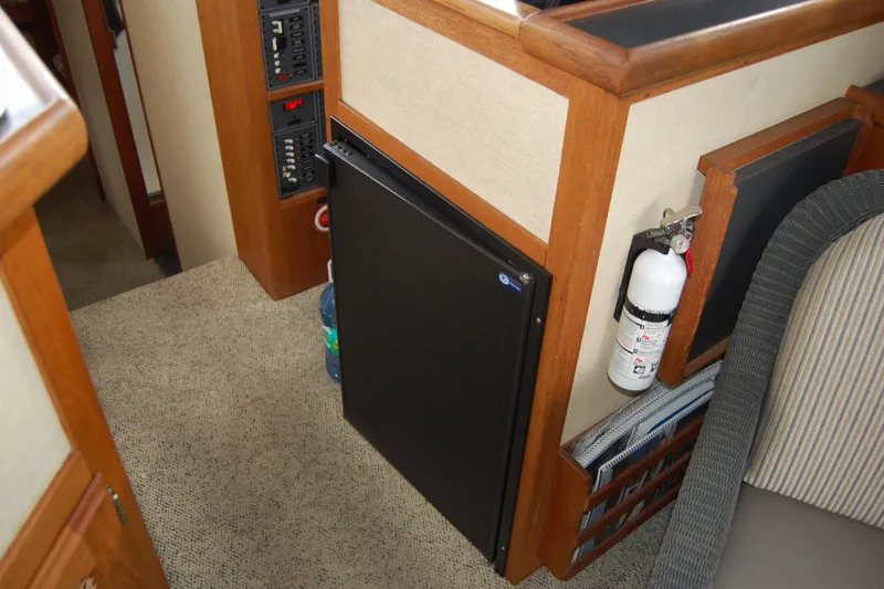Slide: The Image of Interior of 1981 Willard Marine Pilot House Trawler with fridge and fire extinguisher. - 51