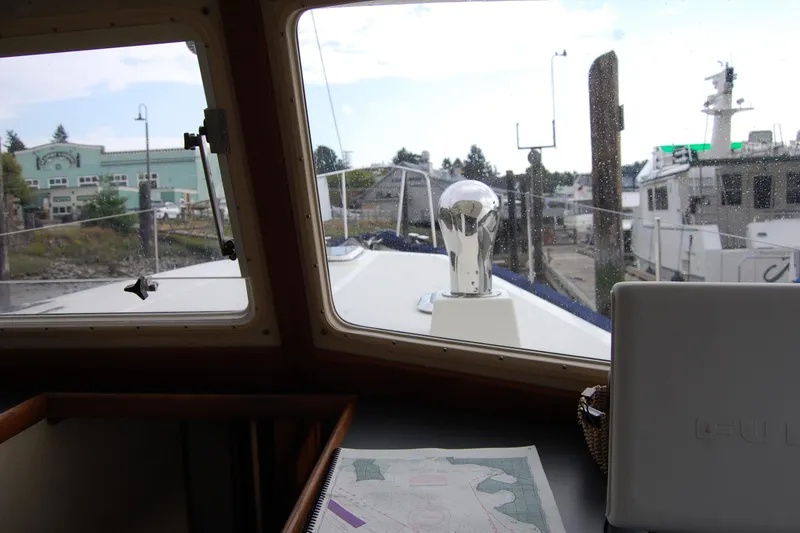 Slide: The Image of Interior view from 1981 Willard Marine Pilot House Trawler, showing navigation map and marina. - 53