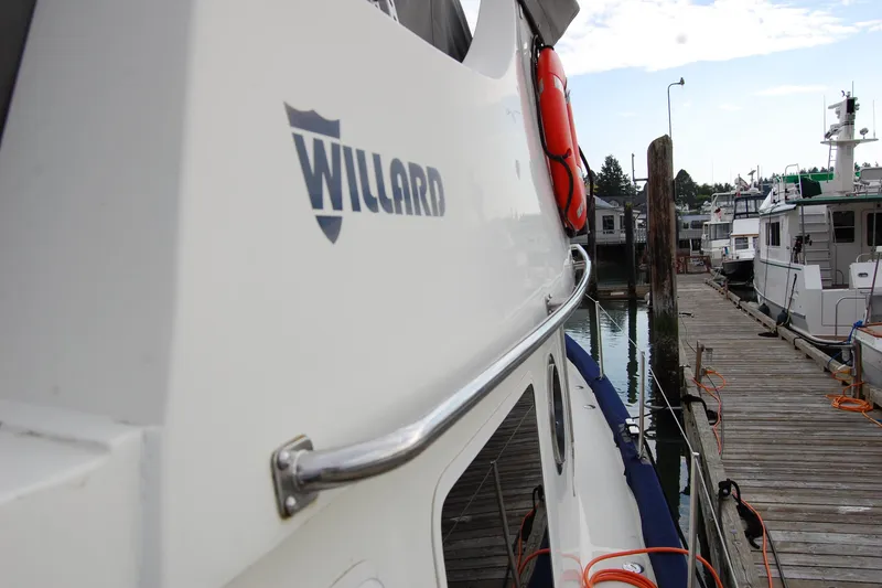 Slide: The Image of 1981 Willard Marine Pilot House Trawler docked at marina, side view with logo. - 59
