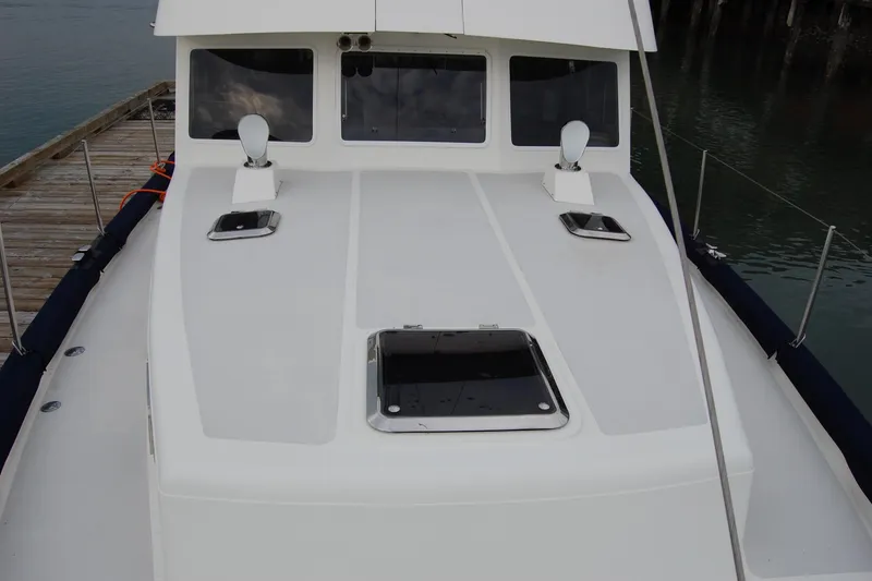 Slide: The Image of 1981 Willard Marine Pilot House Trawler docked, showcasing deck and cabin windows. - 62