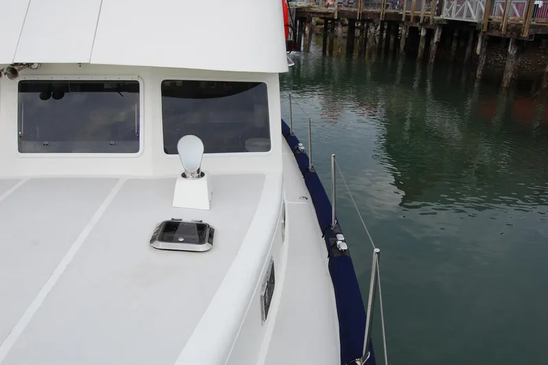 Slide: The Image of 1981 Willard Marine Pilot House Trawler docked, showcasing deck and windows. - 64
