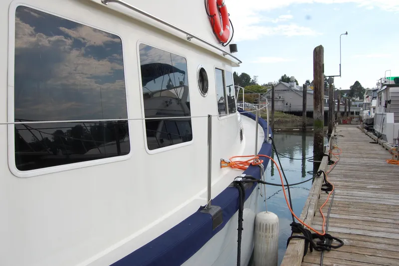 Slide: The Image of 1981 Willard Marine Pilot House Trawler docked at a marina with reflections on windows. - 8