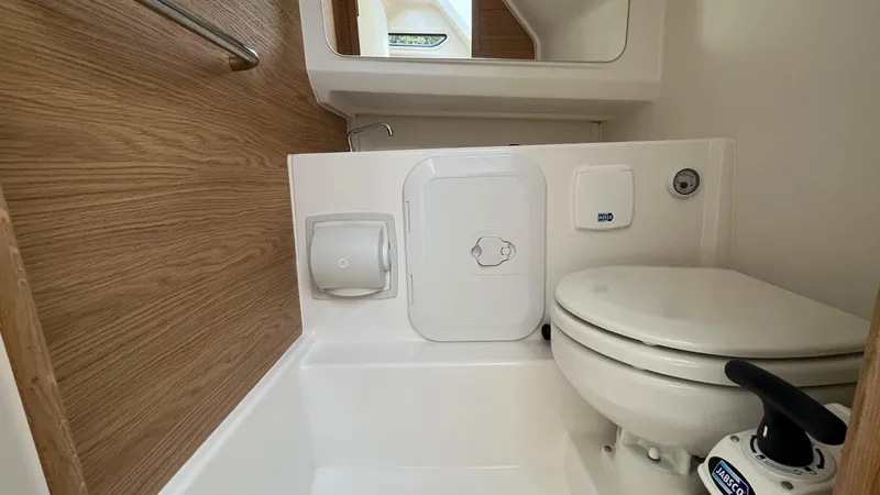 Slide: The Image of Compact bathroom in 2024 Nimbus Tender 8 #314 boat, featuring modern toilet and wooden accents. - 16