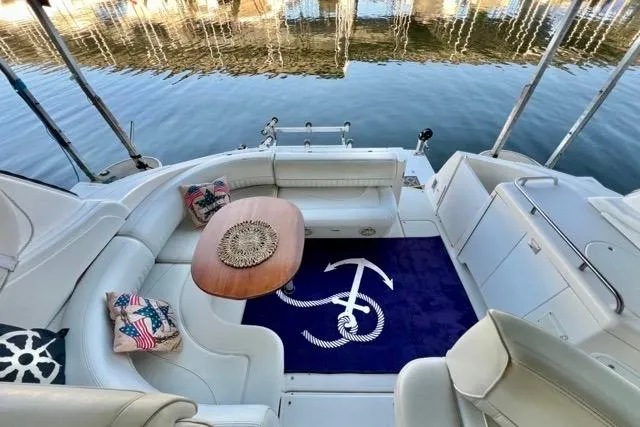 Slide: The Image of 2003 Cruisers Yachts 3772 Express interior with seating, table, and nautical-themed decor. - 10