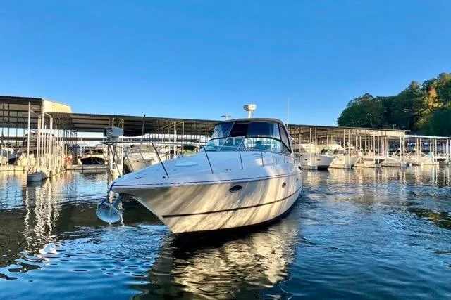 Slide: The Image of 2003 Cruisers Yachts 3772 Express in marina, reflecting on calm water under clear blue sky. - 3
