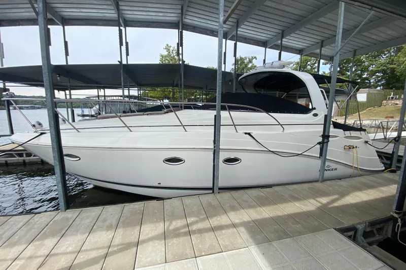 The Image of 2008 Rinker 350 Express Cruiser docked under a covered marina. - 0