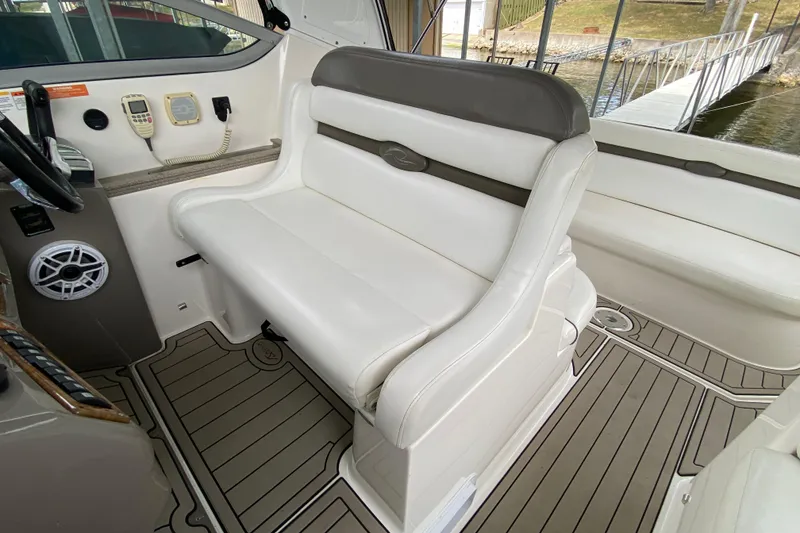 Slide: The Image of 2008 Rinker 350 Express Cruiser interior with white seating and control panel. - 10