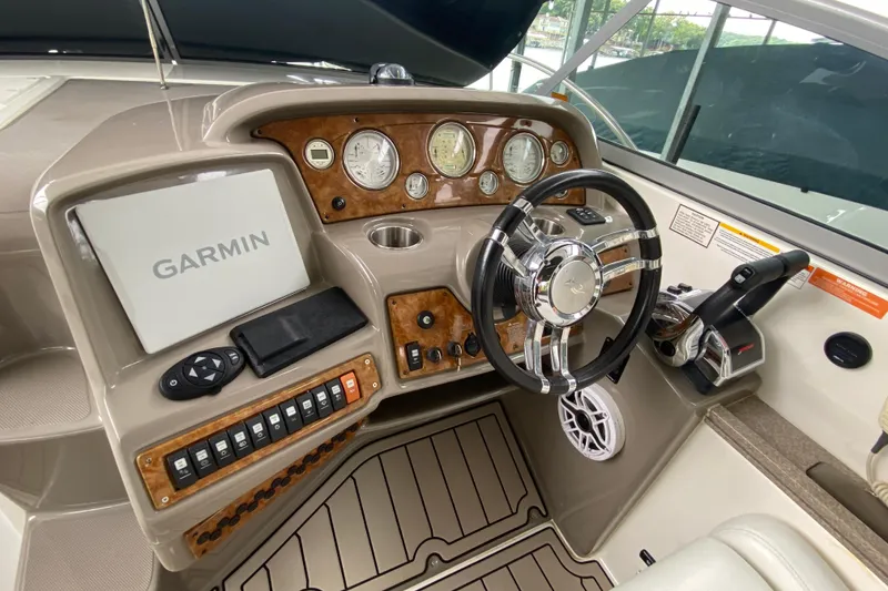 Slide: The Image of 2008 Rinker 350 Express Cruiser helm with Garmin navigation and wood-accented dashboard. - 11