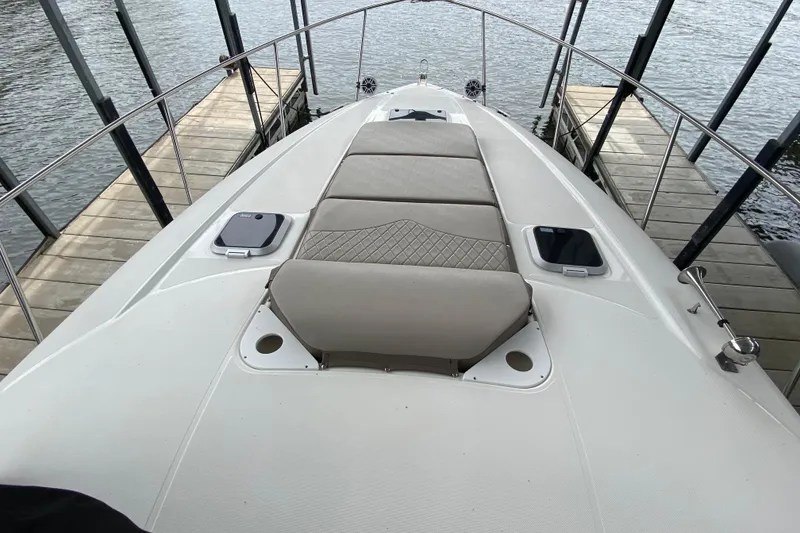 Slide: The Image of 2008 Rinker 350 Express Cruiser bow with cushioned seating, docked by the water. - 16