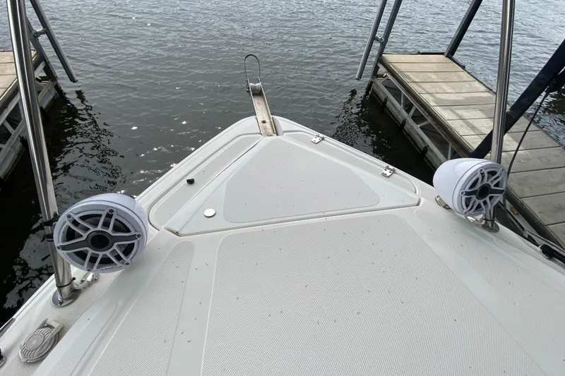 Slide: The Image of 2008 Rinker 350 Express Cruiser bow with speakers, docked on calm water. - 18