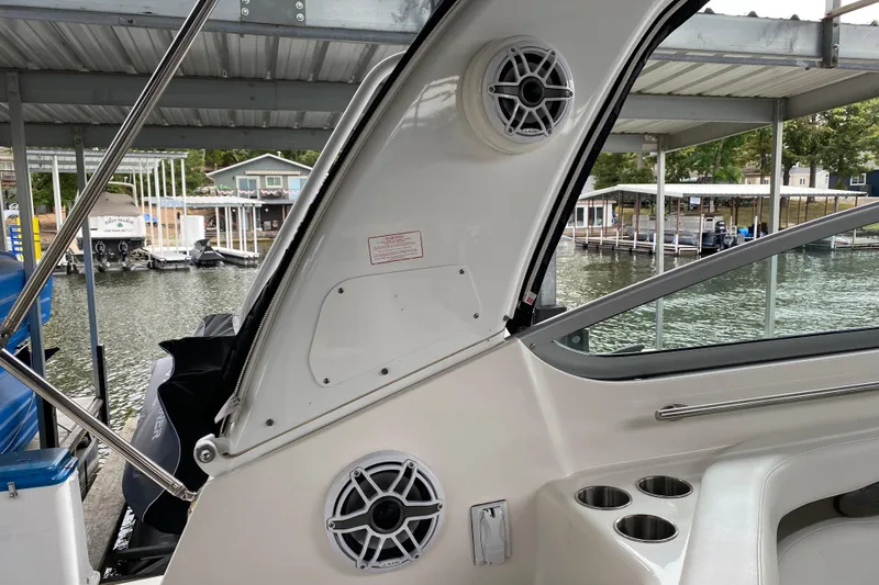 Slide: The Image of 2008 Rinker 350 Express Cruiser interior with speakers and cup holders at a marina. - 20