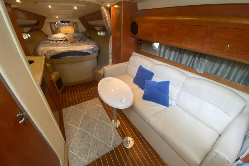 Slide: The Image of 2008 Rinker 350 Express Cruiser interior with cozy bed, sofa, and elegant wood finish. - 25