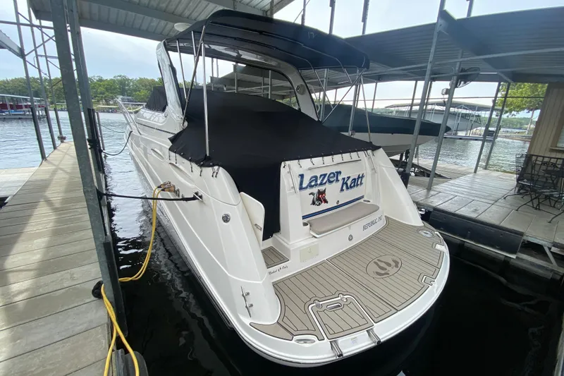 Slide: The Image of 2008 Rinker 350 Express Cruiser docked, covered, with "Lazer Katt" name on the stern. - 3