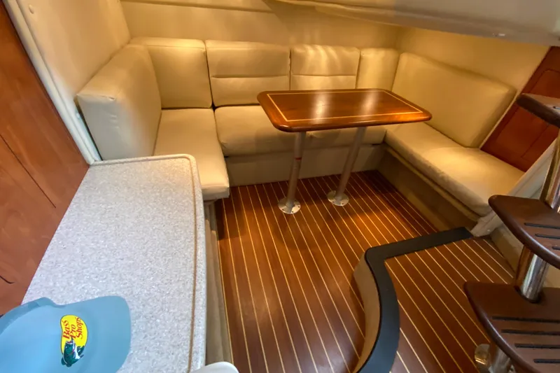 Slide: The Image of 2008 Rinker 350 Express Cruiser interior with cozy seating and wooden table. - 30