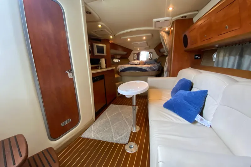 Slide: The Image of 2008 Rinker 350 Express Cruiser interior with cozy seating, kitchenette, and sleeping area. - 31
