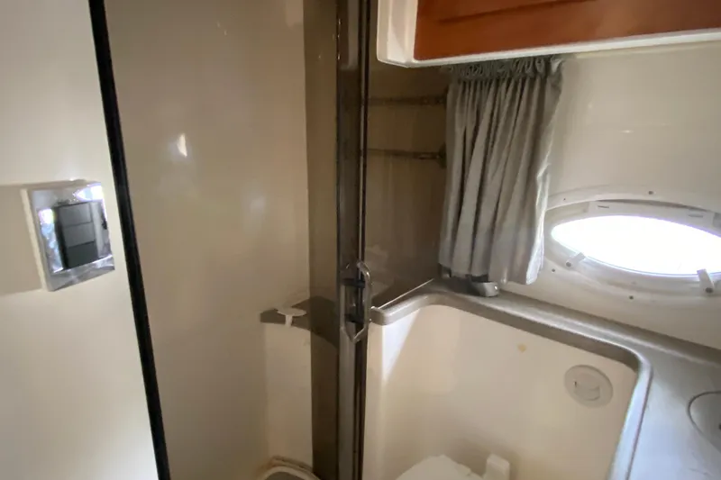 Slide: The Image of 2008 Rinker 350 Express Cruiser bathroom with shower, curtain, and porthole window. - 34