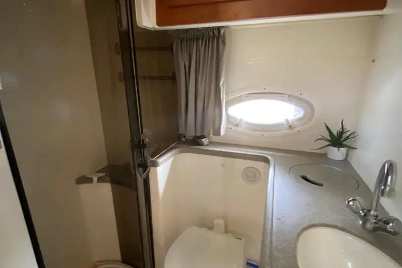 Slide: The Image of 2008 Rinker 350 Express Cruiser bathroom with sink, porthole, and plant. - 35