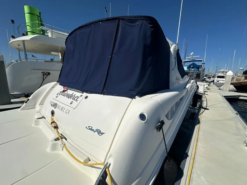 Slide: The Image of 2005 Sea Ray 420 Sundancer yacht docked at marina, rear view with cover. - 10
