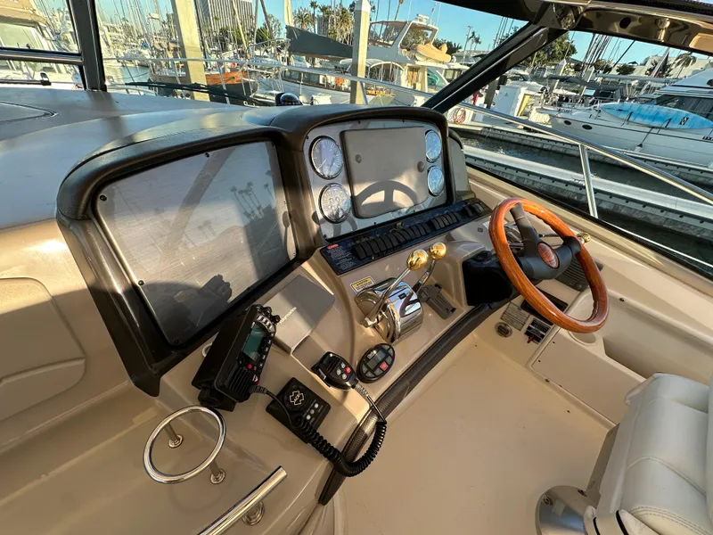 Slide: The Image of 2005 Sea Ray 420 Sundancer helm with gauges and wooden steering wheel. - 21