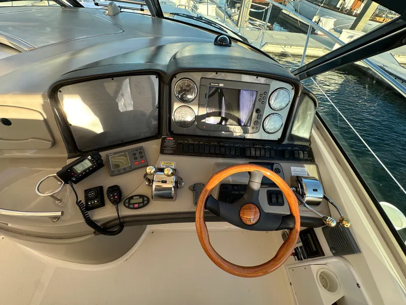 Slide: The Image of 2005 Sea Ray 420 Sundancer helm with wood steering wheel and navigation instruments. - 22