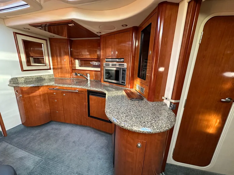 Slide: The Image of Luxurious 2005 Sea Ray 420 Sundancer yacht kitchen with wood cabinetry and granite countertops. - 32