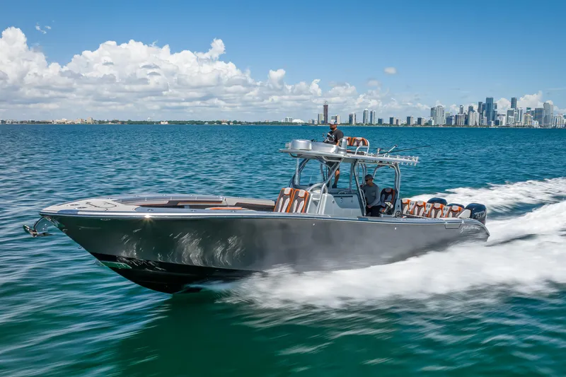 The Image of 2012 Yellowfin 39 boat cruising on blue water with city skyline in the background. - 0