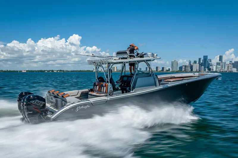 Slide: The Image of 2012 Yellowfin 39 boat cruising on blue ocean with city skyline in background. - 1