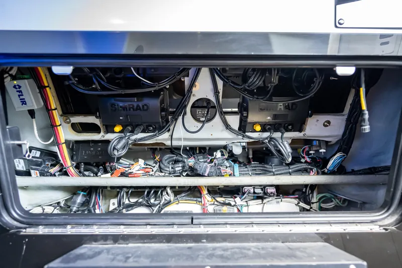 Slide: The Image of 2012 Yellowfin 39 boat electronics compartment with Simrad and FLIR systems, showcasing wiring and equipment. - 10