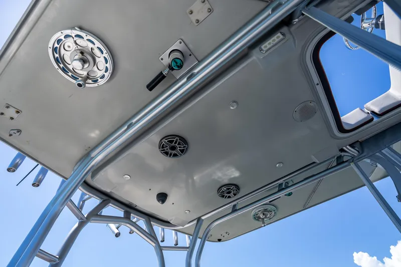 Slide: The Image of 2012 Yellowfin 39 boat's T-top underside with speakers and rod holders against blue sky. - 24