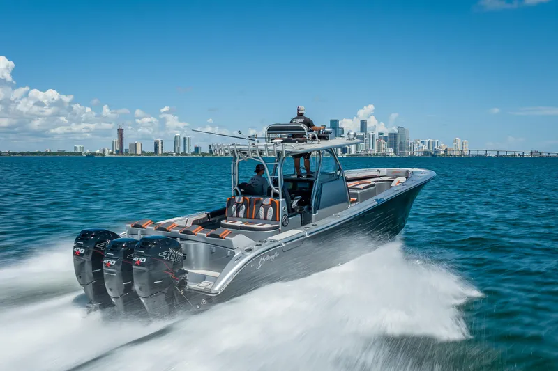 Slide: The Image of 2012 Yellowfin 39 boat cruising on water with city skyline in background. - 3