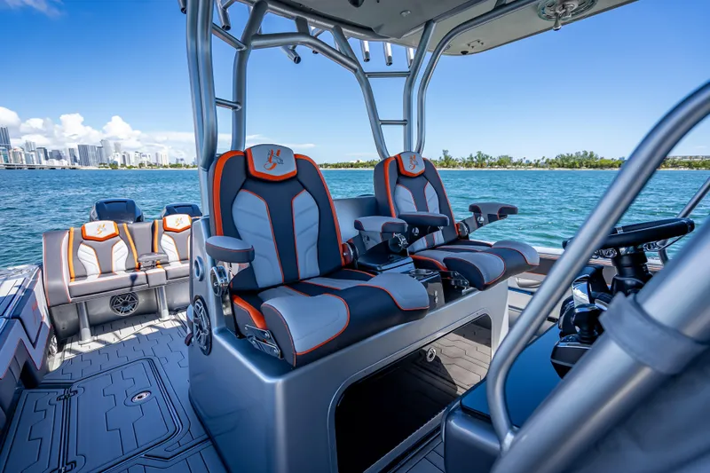Slide: The Image of 2012 Yellowfin 39 boat interior with luxury seating, ocean view, and city skyline in background. - 34