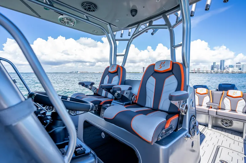 Slide: The Image of 2012 Yellowfin 39 boat interior with luxury seating, ocean view, and city skyline in background. - 46