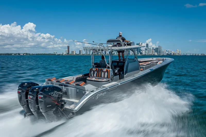 Slide: The Image of 2012 Yellowfin 39 boat cruising on blue water with city skyline in background. - 55