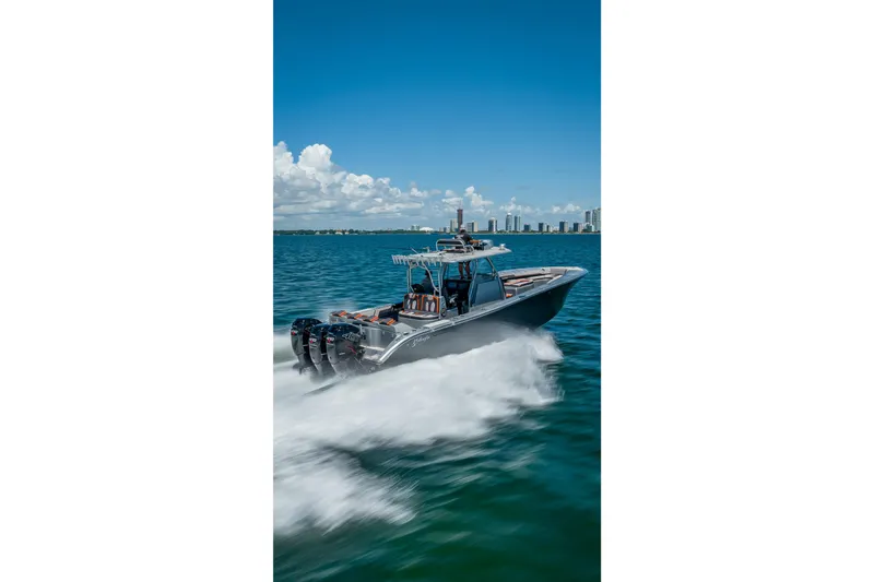 Slide: The Image of 2012 Yellowfin 39 boat cruising on blue ocean with city skyline in background. - 57