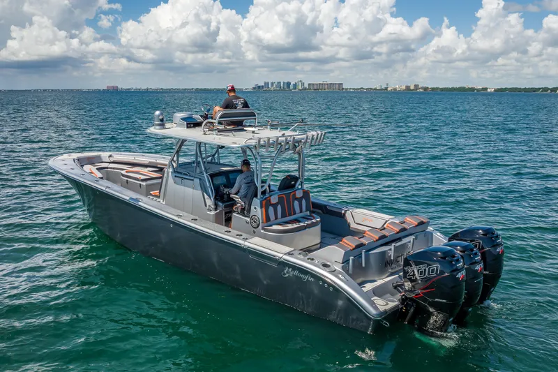 Slide: The Image of 2012 Yellowfin 39 boat on open water, featuring triple outboard engines and sleek design. - 67