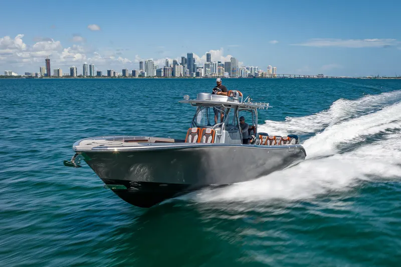 Slide: The Image of 2012 Yellowfin 39 boat cruising on blue ocean with city skyline in background. - 70