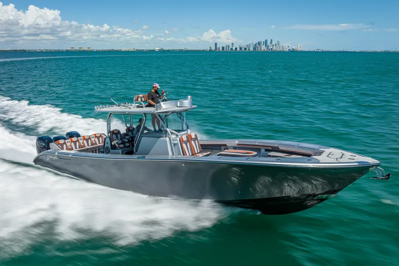 Slide: The Image of 2012 Yellowfin 39 boat cruising on turquoise waters with city skyline in background. - 72