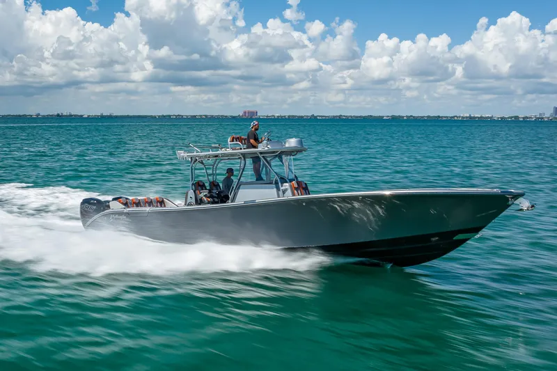 Slide: The Image of 2012 Yellowfin 39 boat cruising on clear blue ocean under a partly cloudy sky. - 74