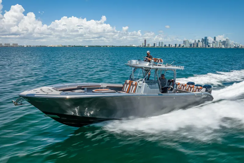 Slide: The Image of 2012 Yellowfin 39 boat cruising on blue ocean with city skyline in background. - 77
