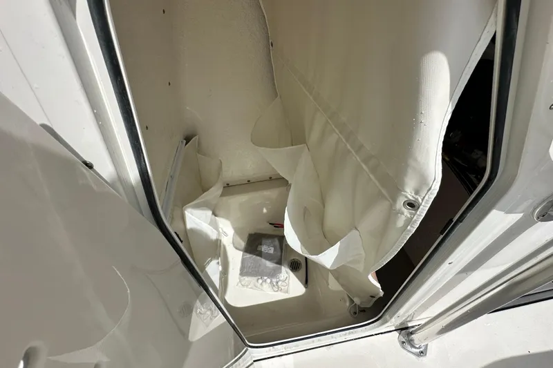 Slide: The Image of 2026 Key West 219 FS boat interior storage compartment with curtain. - 14