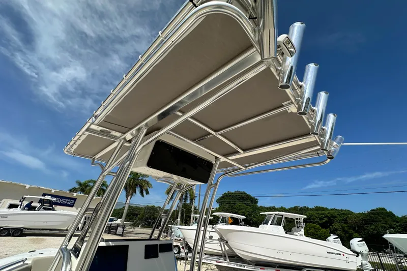 Slide: The Image of 2026 Key West 219 FS boat with T-top and rod holders under clear blue sky. - 16