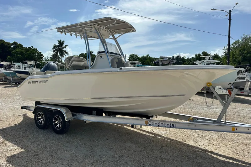 Slide: The Image of 2026 Key West 219 FS boat on trailer, parked outdoors under clear sky. - 6